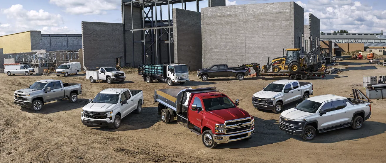 Chevrolet commercial fleet lineup on a job site, from work vans and Silverado pickups to chassis cab and medium-duty trucks